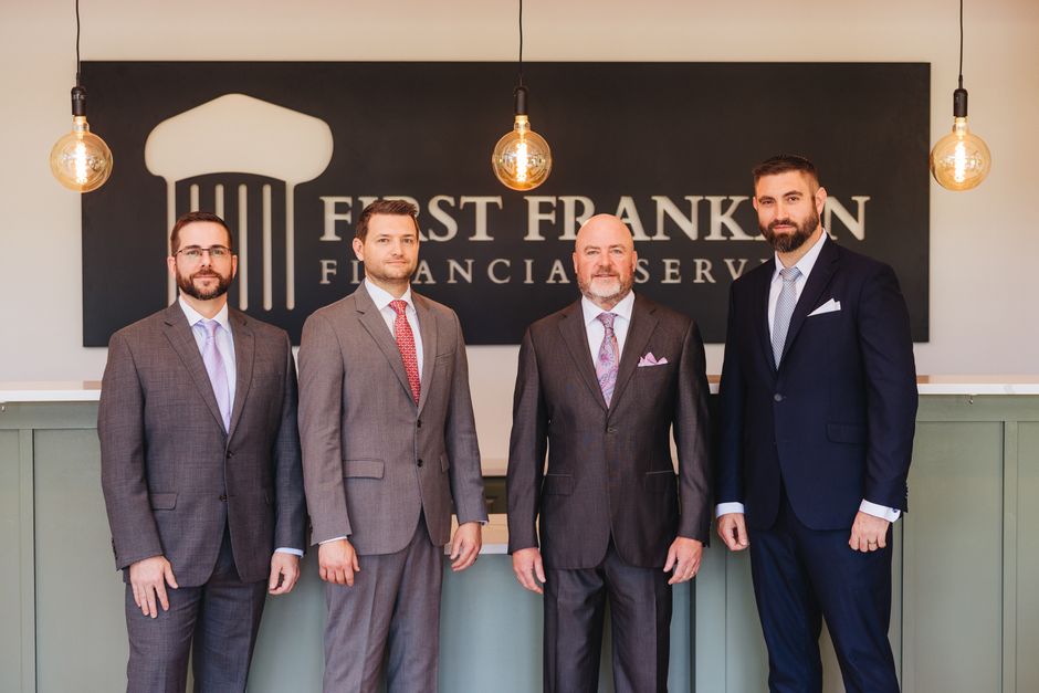 Group of businessmen posing in office setting at First Franklin Financial Services.